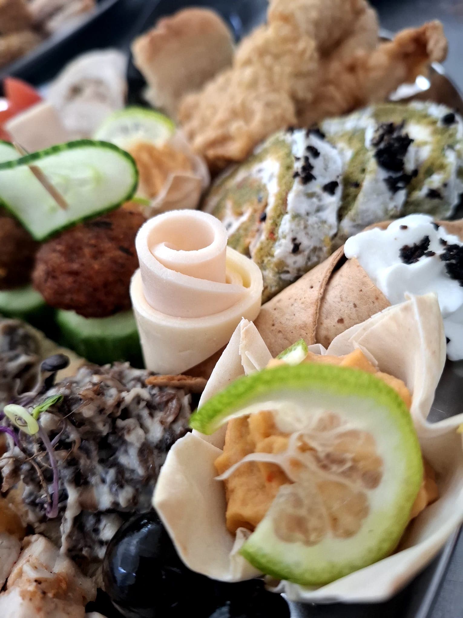 Detaliu de platou aperitiv cu cornete, salate și tartine