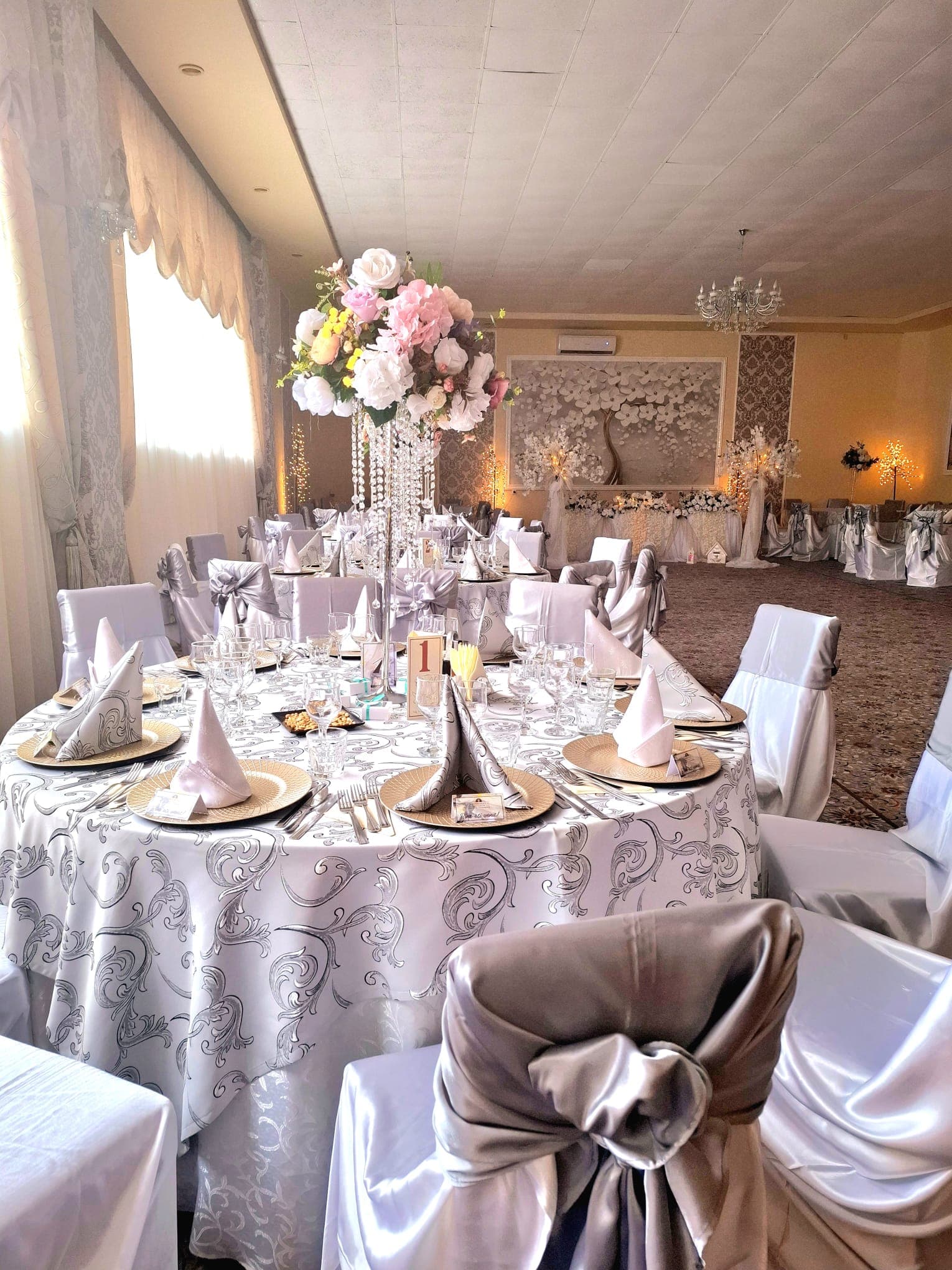 Salon principal Restaurant Ardealul cu mese rotunde, huse argintii și aranjamente înalte