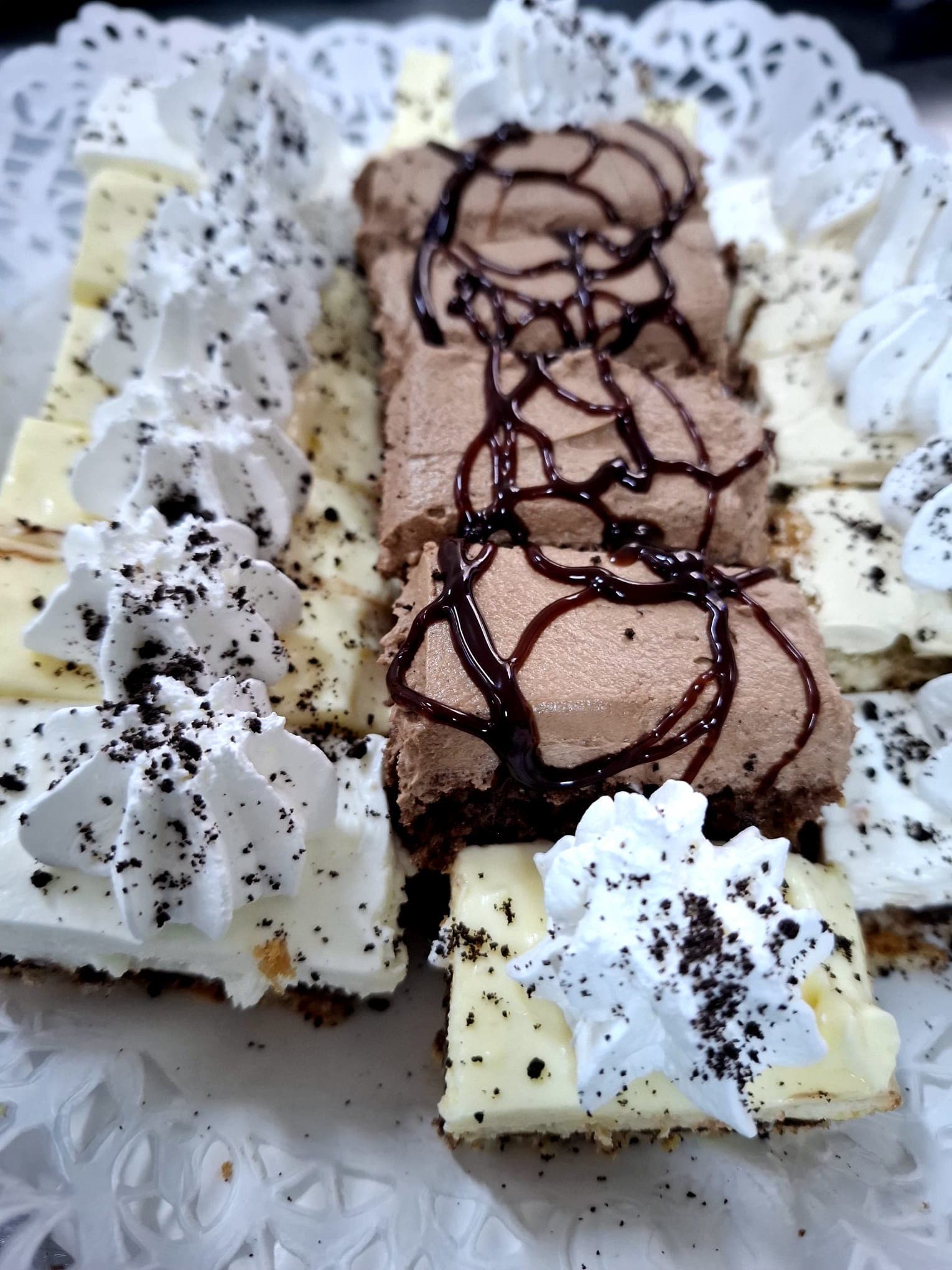 Prăjituri cu ciocolată, vanilie și frișcă pe platou de desert
